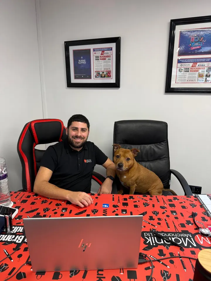 Maxx at his desk with Ruby beside him on the chair