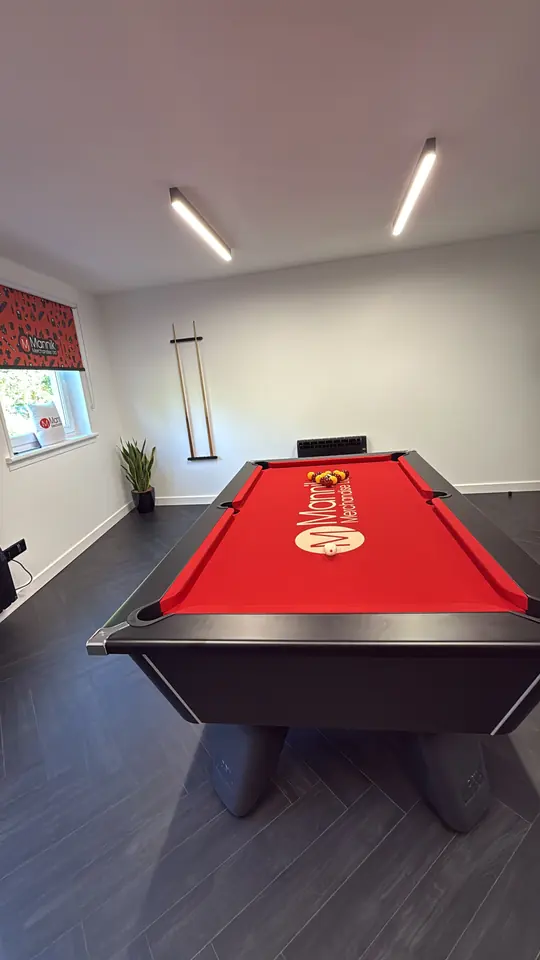 Office room with a red pool table printed with the Mannik logo