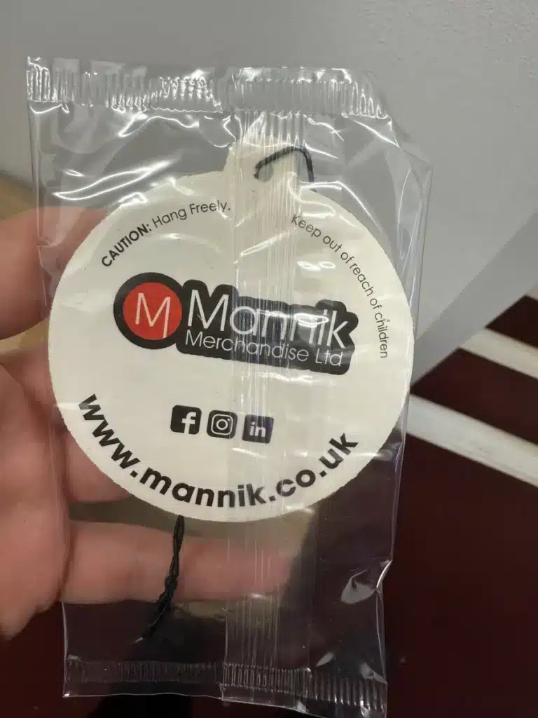 Individually bagged Mannik branded bauble air freshener sample with black elastic